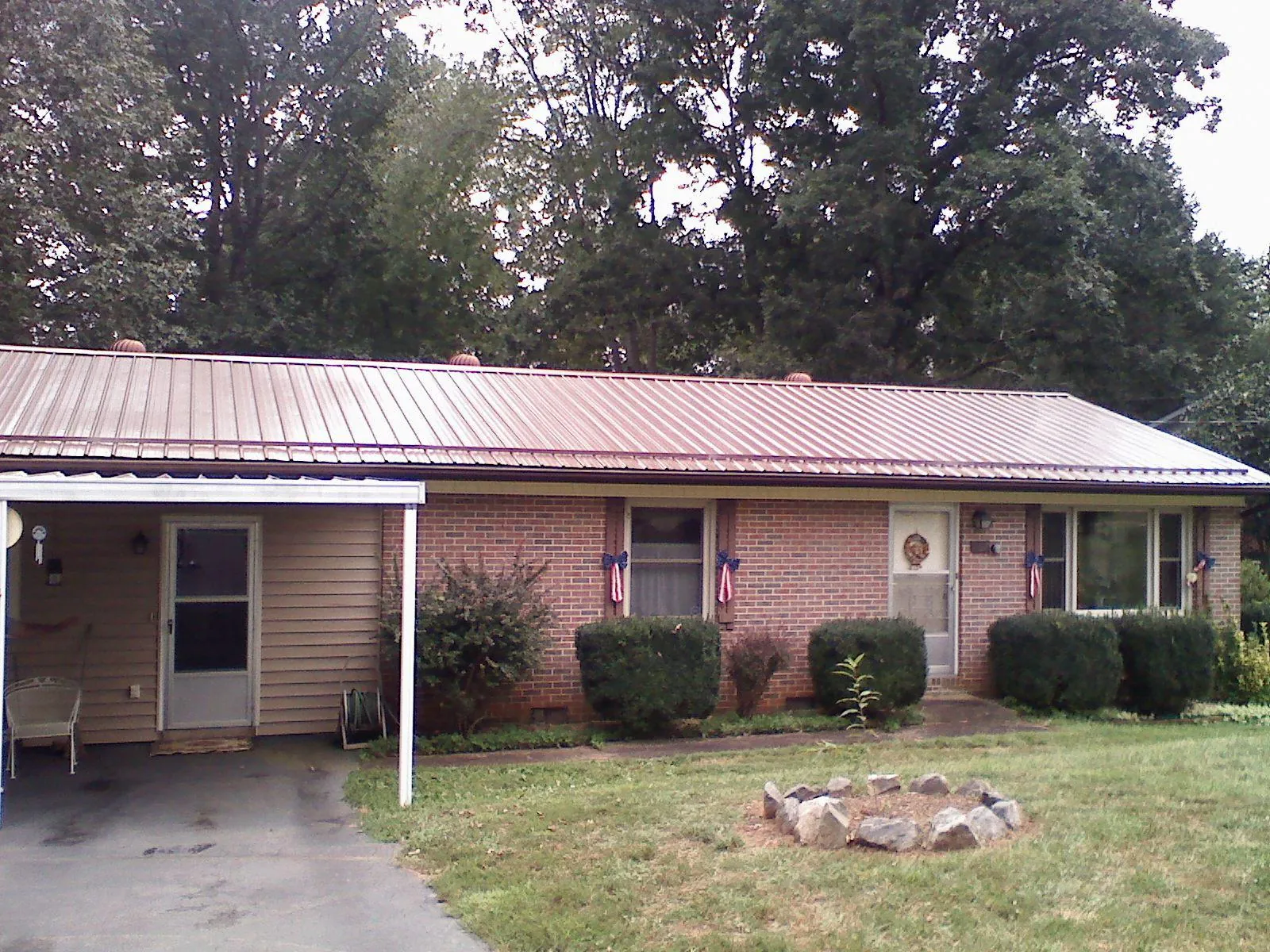 Bronze metal roof and carport on a brick ranch home — Roof Repair work by our crew in Spring Branch