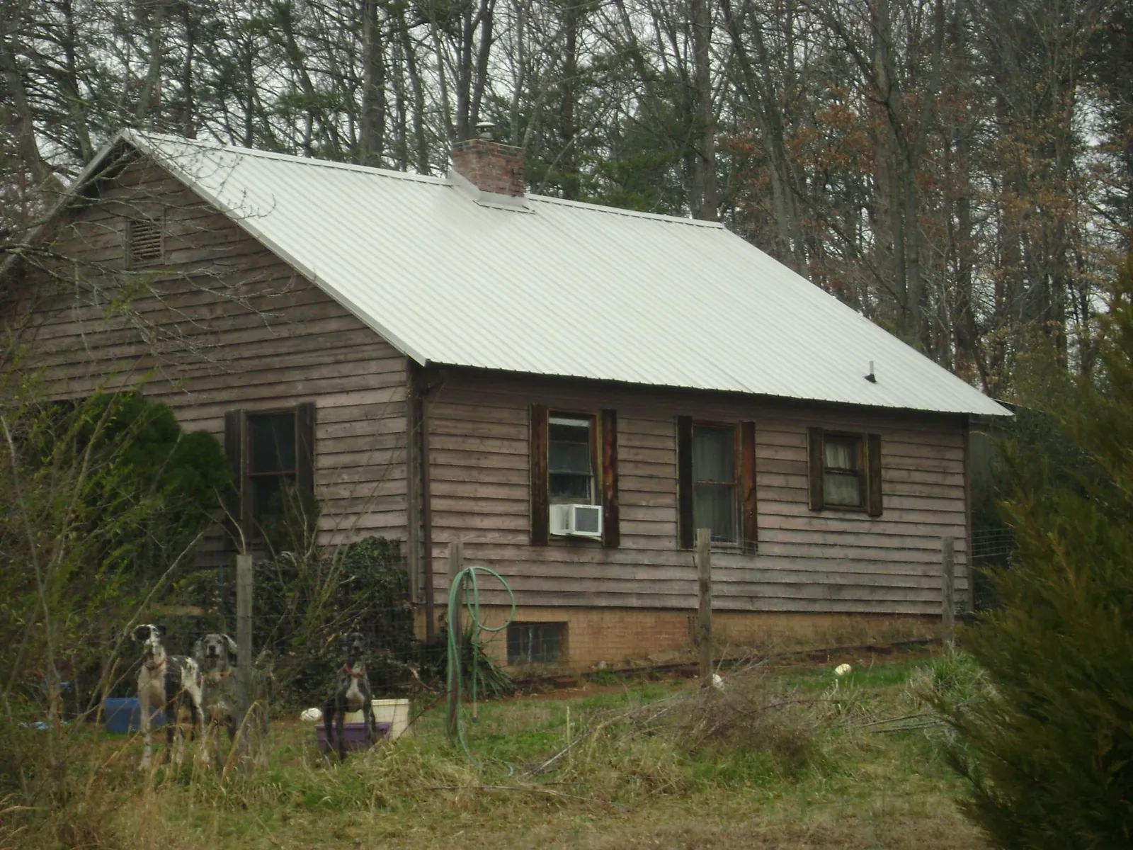 White metal roof on an old wood sided farmhouse, from a Asphalt Shingle Roof Repair job in Spring Branch